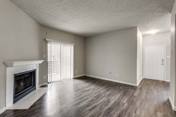 A room with a fireplace and wood flooring.
