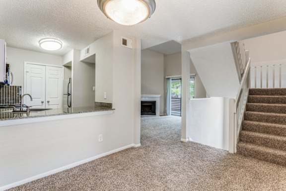 A spacious living room with a staircase leading to the upper floor.