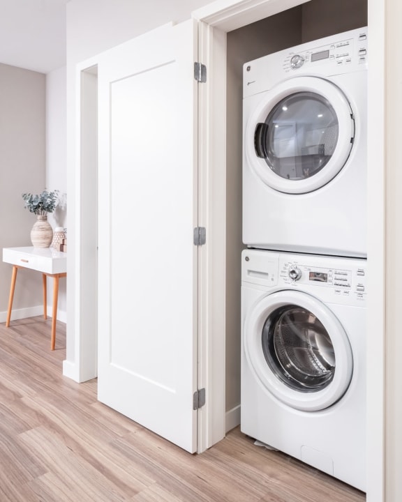 a white washer and dryer in a white laundry room