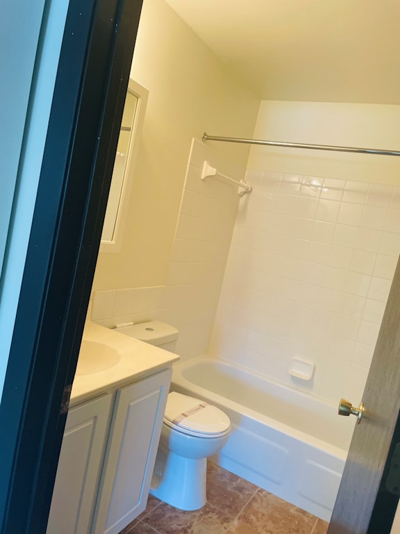 A white toilet sits in a bathroom next to a bathtub.