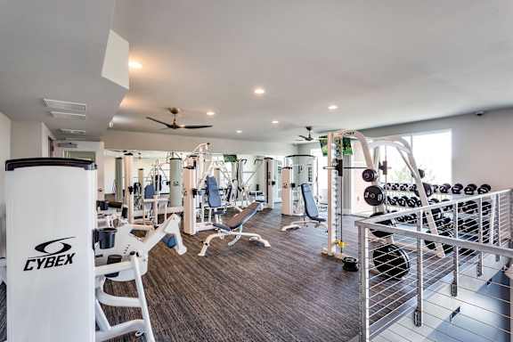 A gym with a variety of equipment including a Cybex weight machine.