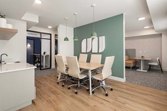 A modern office space with a green accent wall and white furniture.