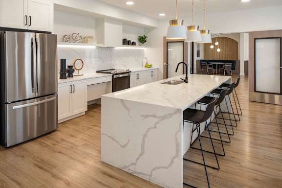 A modern kitchen with a marble island and stainless steel appliances.