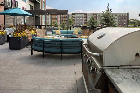 A patio with a grill and a hot tub.