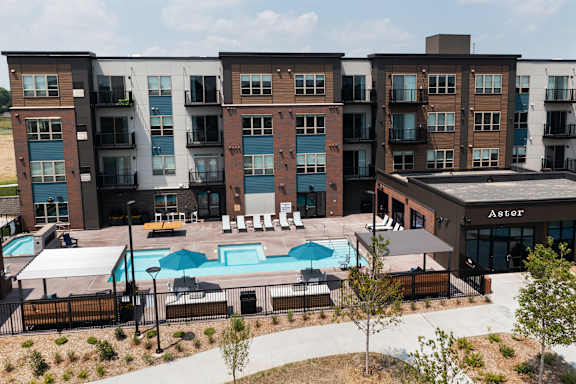 A large apartment complex with a pool in the middle.