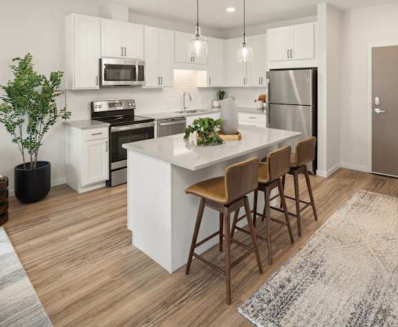 A kitchen with white cabinets and a wooden island.