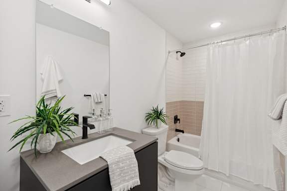 A bathroom with a sink, toilet, and shower.