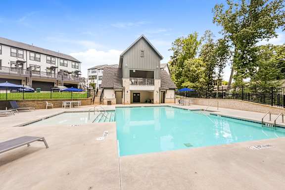 A swimming pool in a residential area with a building in the background.
