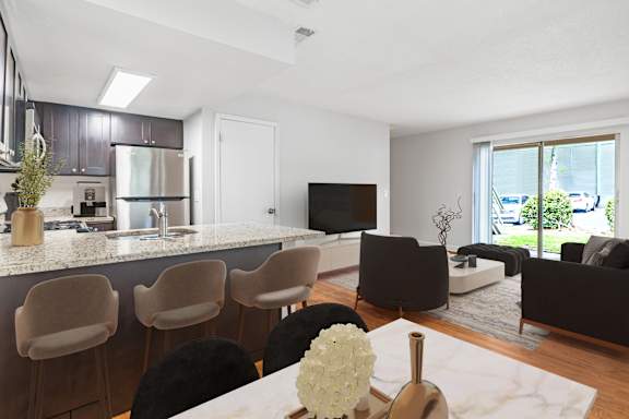 A modern kitchen with a bar area and a living room area.