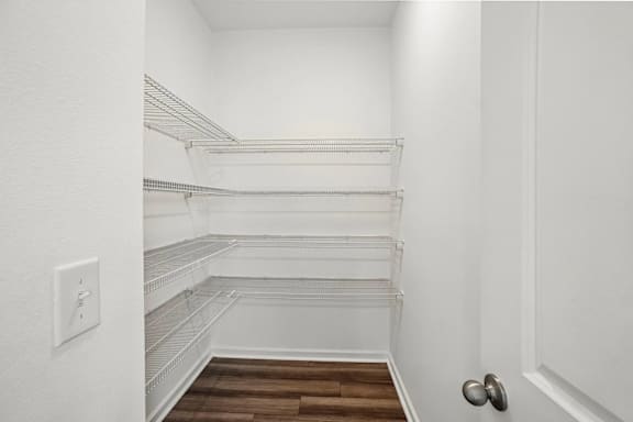 Empty white walk in closet with shelves.