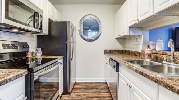 The Monroe Apartments in Glendale Heights, IL photo of a kitchen with granite countertops and stainless steel appliances