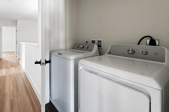 A white washing machine and dryer in a laundry room.