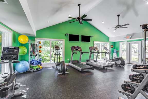 A gym with a green wall and various exercise equipment.