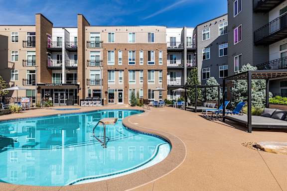 A swimming pool in front of apartment buildings.