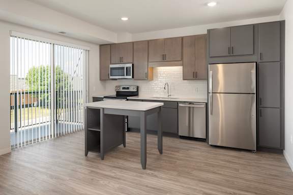 A modern kitchen with a table and stainless steel appliances.