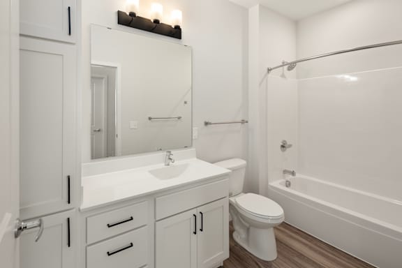 A white bathroom with a toilet, sink, and bathtub.
