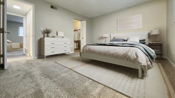A bedroom with a large bed and a dresser.