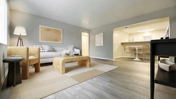 A living room with a grey couch, a wooden table, and a rug.