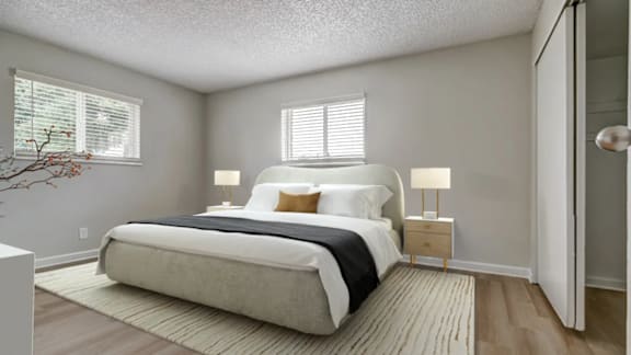 A bedroom with a large bed and two lamps.