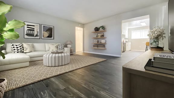 A living room with a white sofa and a wooden floor.