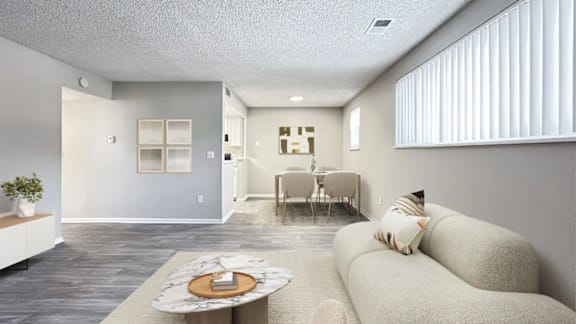 A living room with a couch, a coffee table, and a dining table.