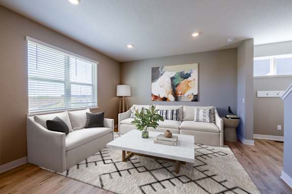 A living room with a white couch, a coffee table, and a painting on the wall.
