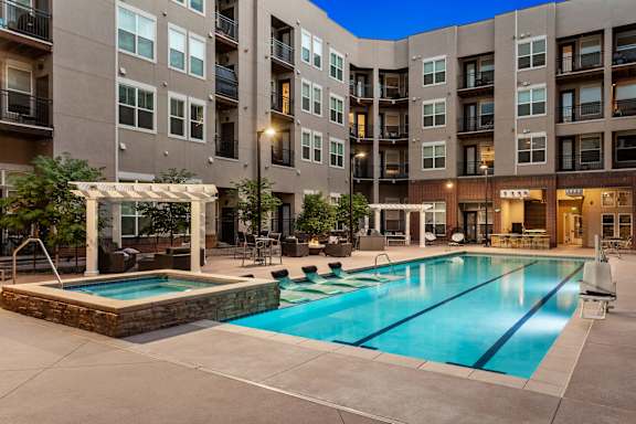 A large swimming pool in front of apartment buildings.