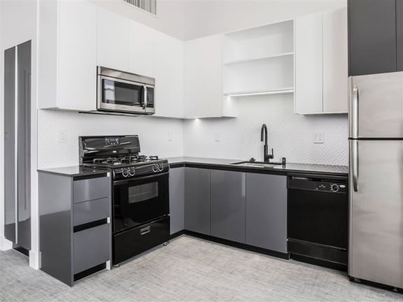 Fully Equipped Kitchens with Stainless or Black Appliances and Quartz or Granite Countertops