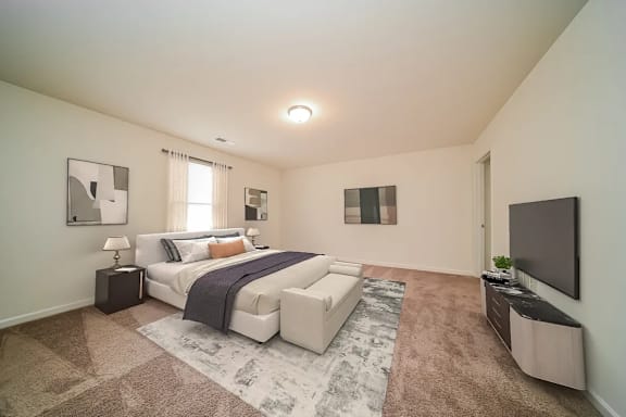 A bedroom with a large bed and a flat screen TV.