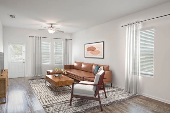 A living room with a brown sofa, a coffee table, and a ceiling fan.