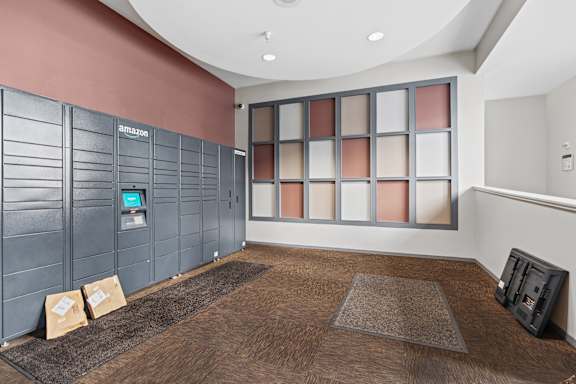 A room with a brown carpet and a wall with Amazon written on it.