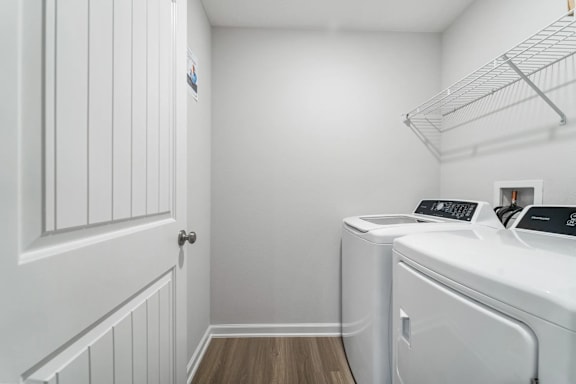 A white laundry room with a washer and dryer.