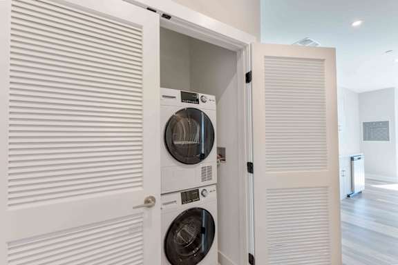 A white washing machine is built into a wall.