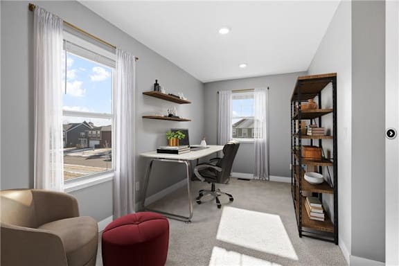 A modern home office with a desk, chair, and bookshelf.