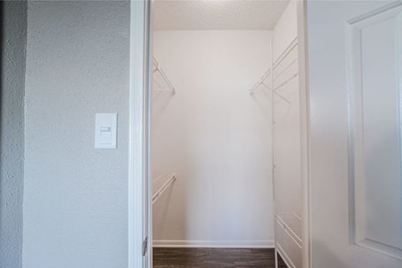 A white door is open to a hallway with a light switch on the wall.