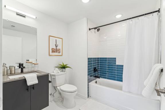 A bathroom with a white toilet, a white bathtub, and a white sink.