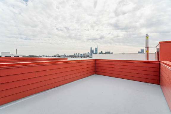 A red-roofed building with a view of a city skyline in the distance.