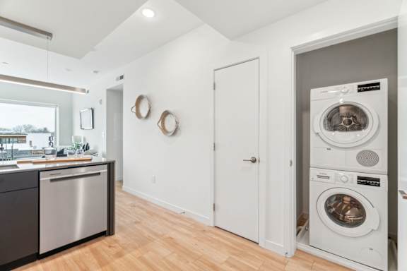 A modern laundry room with a washer and dryer stacked on top of each other.