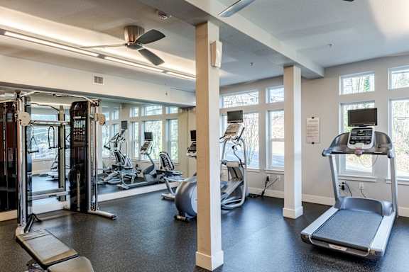 A gym with treadmills, elliptical machines, and other exercise equipment.