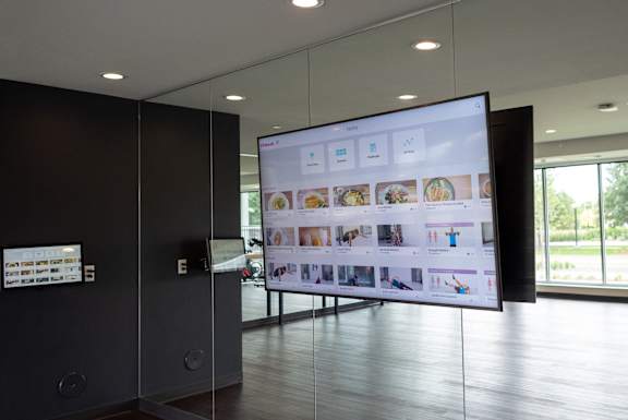 A wall of monitors displays a variety of images and icons.