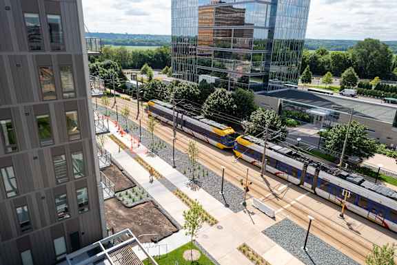 A train is passing by a modern building.