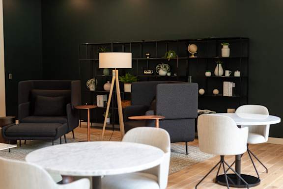 A modern living room with a white table and black chairs.