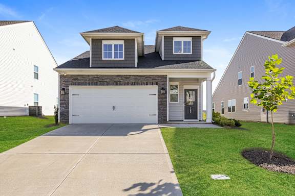 A two-story house with a garage and a driveway.
