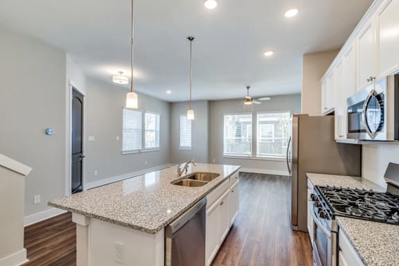 A kitchen with a granite countertop and a stainless steel oven.
