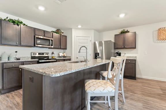A kitchen with a granite countertop and a chair.
