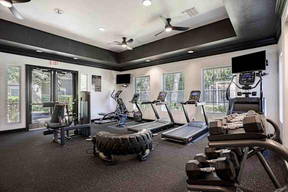 A gym with treadmills, weights, and exercise equipment.