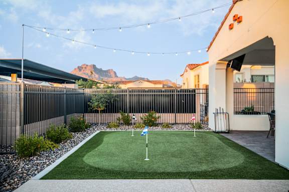 A small artificial lawn with a golf hole flag in the middle.