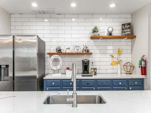 A kitchen with a stainless steel refrigerator and a white countertop.