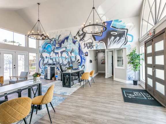 A room with a graffiti wall and wooden floors.