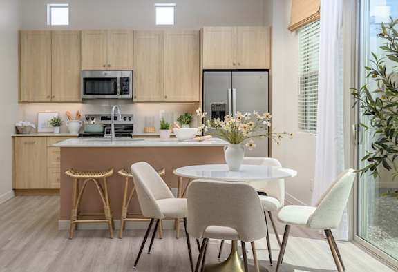 A modern kitchen with a dining table set for four.